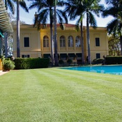 Foto de uma casa com o gramado de Grama Zeon aparada e piscina ao lado