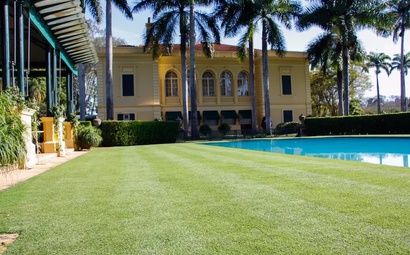 Foto de uma casa com o gramado de Grama Zeon aparada e piscina ao lado