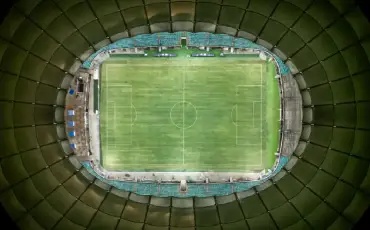 Gramado fonte nova sendo visto de cima enquanto está com as arquibancadas vazias, mostrando apenas o gramado